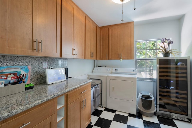 washroom featuring wine cooler, cabinets, and independent washer and dryer