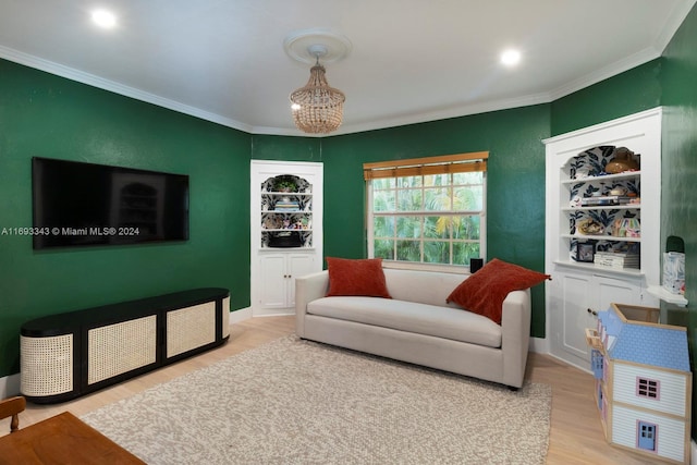 living room with light wood-type flooring, ornamental molding, and an inviting chandelier