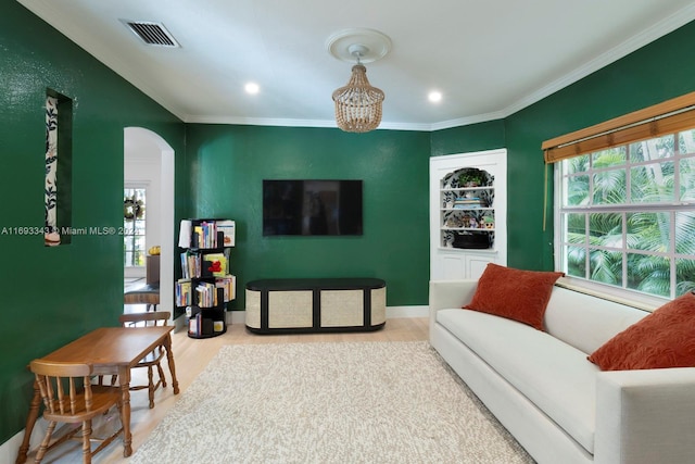 living room featuring a chandelier, hardwood / wood-style floors, and crown molding