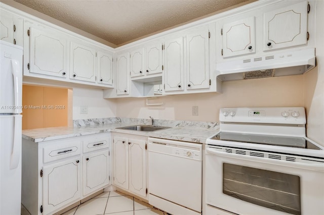 kitchen with white appliances, sink, light tile patterned floors, a textured ceiling, and white cabinetry