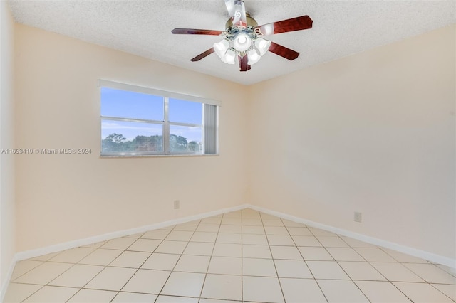 tiled empty room with a textured ceiling and ceiling fan