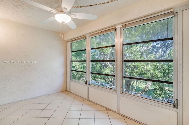 tiled empty room featuring a wealth of natural light and ceiling fan