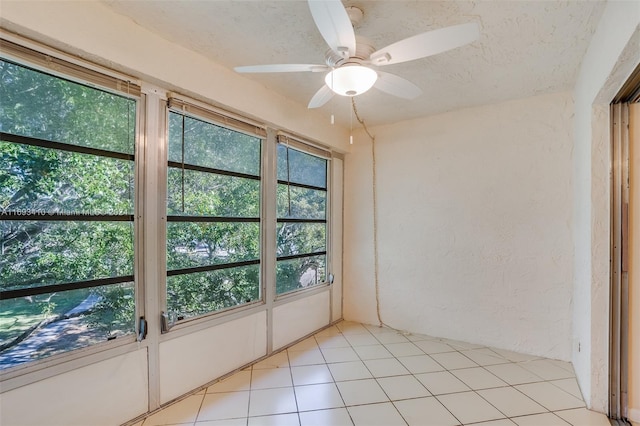 unfurnished sunroom featuring ceiling fan