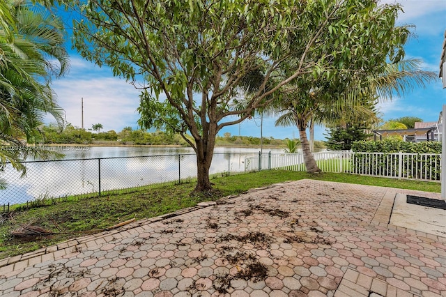 view of yard with a patio, a water view, and a fenced backyard