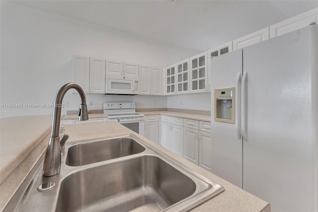 kitchen with light countertops, glass insert cabinets, white cabinetry, a sink, and white appliances