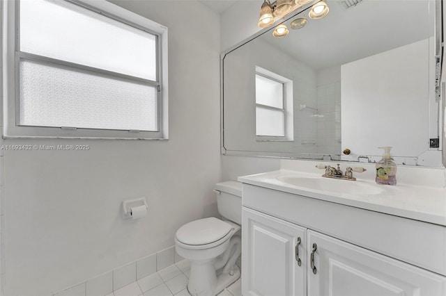 bathroom featuring toilet, tile patterned floors, baseboards, and vanity