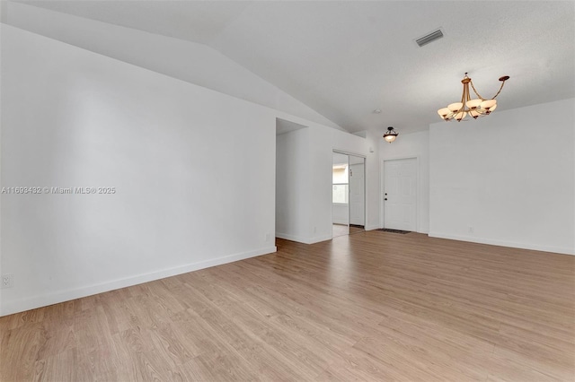 unfurnished room featuring a notable chandelier, visible vents, baseboards, vaulted ceiling, and light wood finished floors