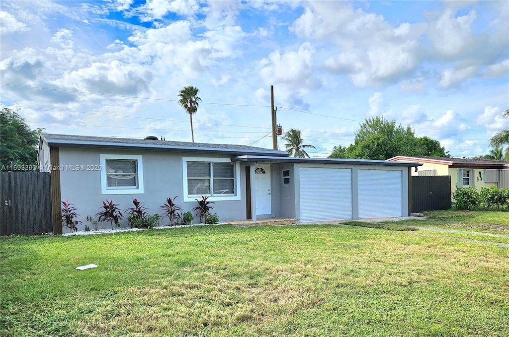 single story home with a garage, a front lawn, fence, and stucco siding