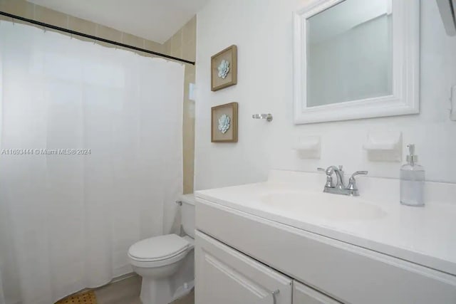 bathroom featuring curtained shower, vanity, and toilet