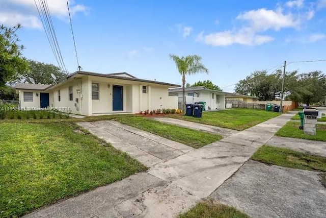 single story home featuring a front lawn