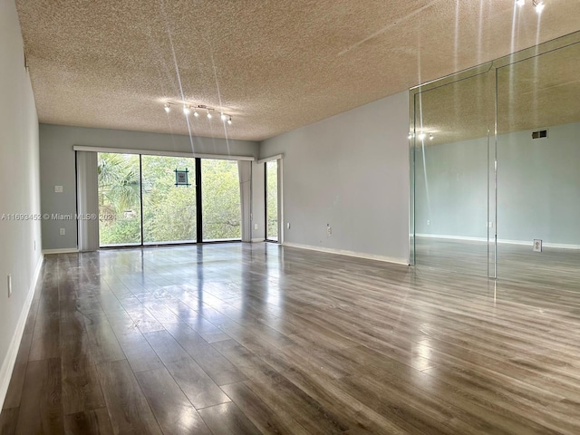 spare room with a textured ceiling and hardwood / wood-style flooring