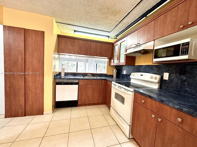 kitchen with sink, dishwashing machine, light tile patterned floors, decorative backsplash, and electric stove