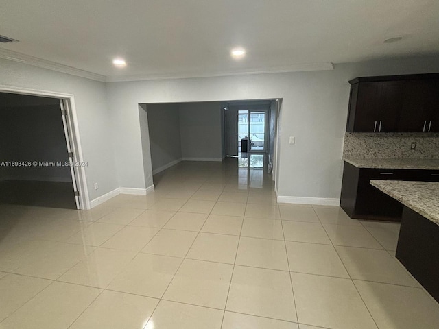 interior space with light tile patterned floors and ornamental molding