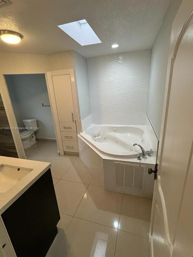 bathroom with tile patterned flooring, vanity, a textured ceiling, and toilet