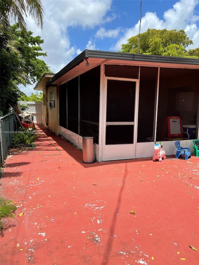 back of property featuring a sunroom, cooling unit, and a patio area