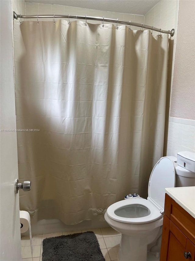 bathroom featuring toilet, a shower with curtain, vanity, and tile patterned floors