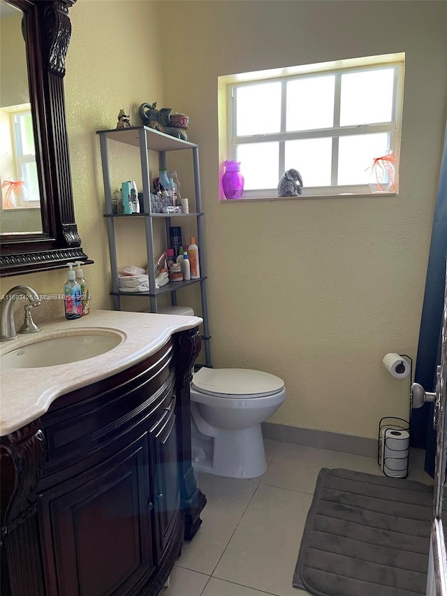 bathroom featuring vanity, tile patterned flooring, plenty of natural light, and toilet