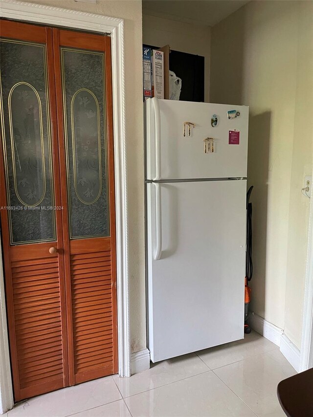 kitchen with light tile patterned floors and white refrigerator