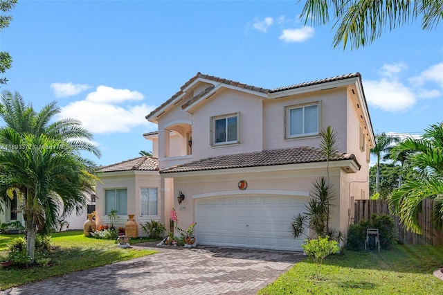 mediterranean / spanish house with a garage and a front lawn