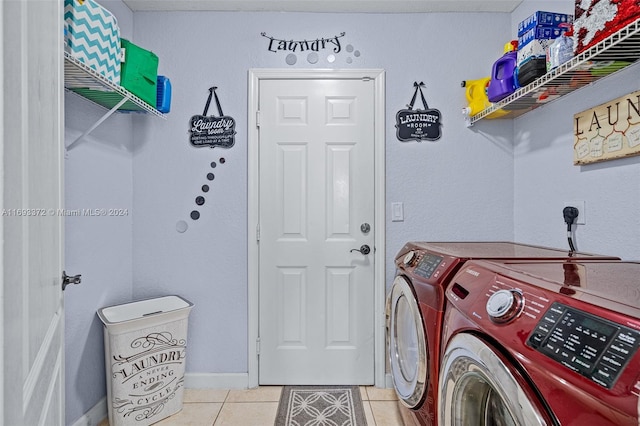 laundry area featuring light tile patterned floors and washing machine and clothes dryer