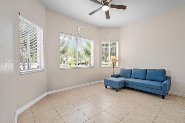 living area with light tile patterned floors and ceiling fan