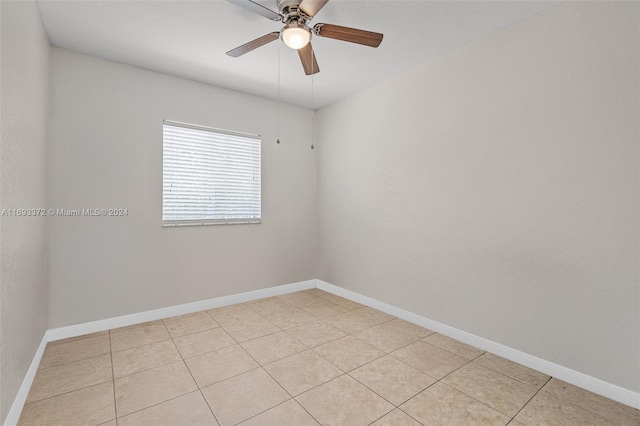 tiled empty room featuring ceiling fan