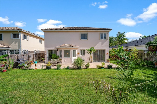 rear view of property with a yard and a patio area