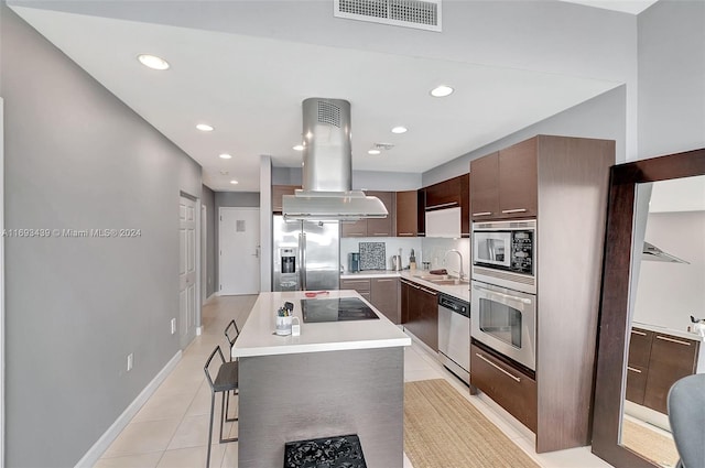 kitchen with dark brown cabinetry, sink, appliances with stainless steel finishes, a kitchen island, and island exhaust hood