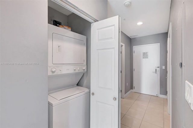 laundry room featuring light tile patterned flooring and stacked washer / dryer