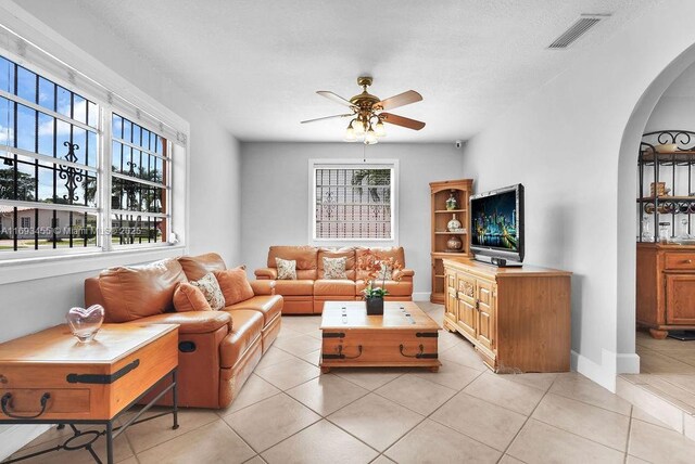 tiled living room featuring ceiling fan