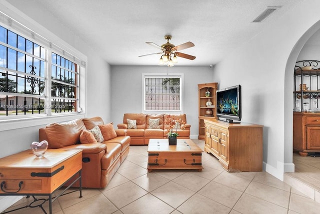 living room featuring a healthy amount of sunlight, light tile patterned floors, and ceiling fan