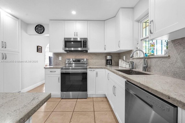 kitchen with sink, white cabinets, and appliances with stainless steel finishes