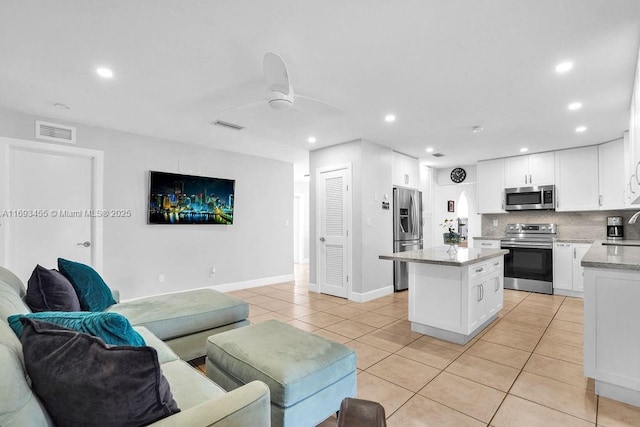 living room featuring ceiling fan, sink, and light tile patterned flooring