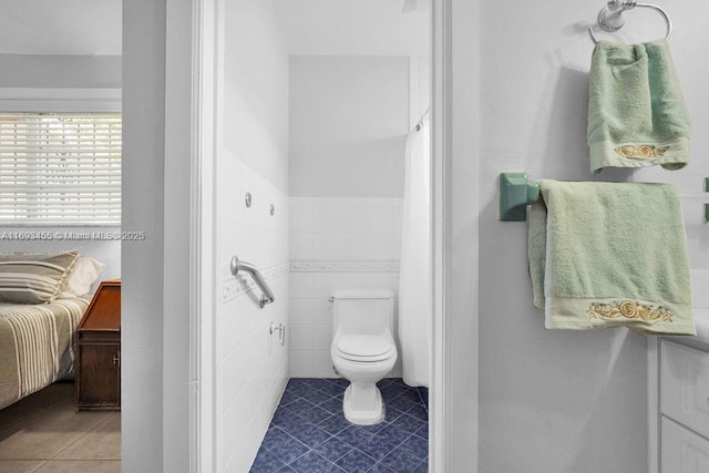 bathroom featuring tile walls, toilet, and tile patterned flooring