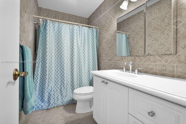 bathroom with tile patterned floors, vanity, tile walls, toilet, and a shower with shower curtain