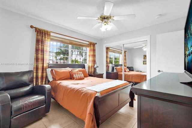 tiled bedroom with ceiling fan and a closet