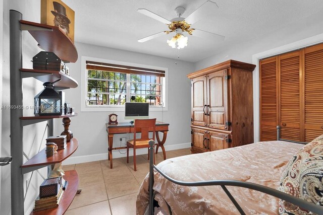 bedroom featuring ceiling fan, light tile patterned floors, and a closet