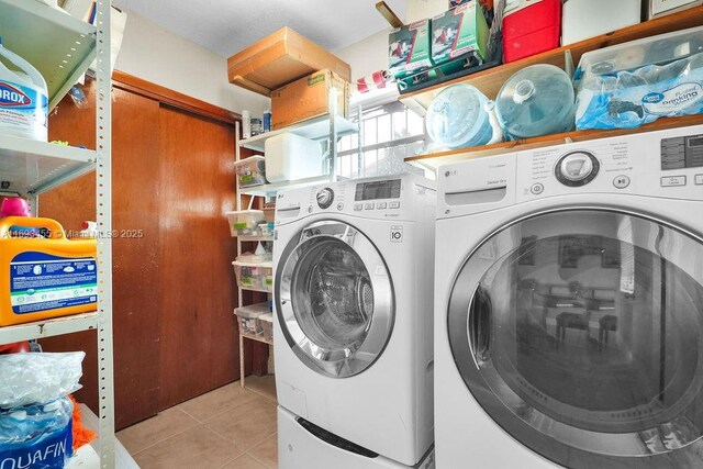 washroom with washer and clothes dryer and light tile patterned floors