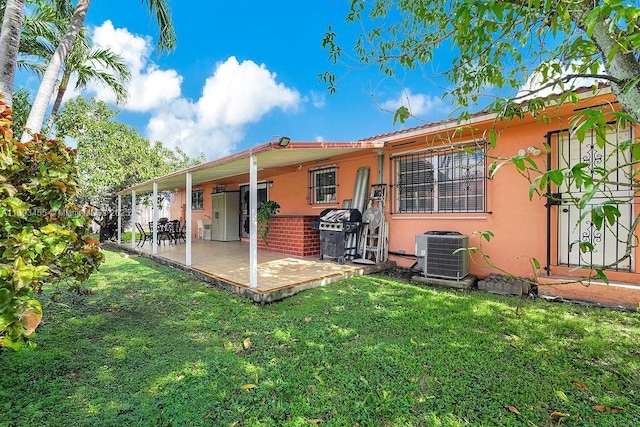 back of house featuring central AC unit, a yard, and a patio