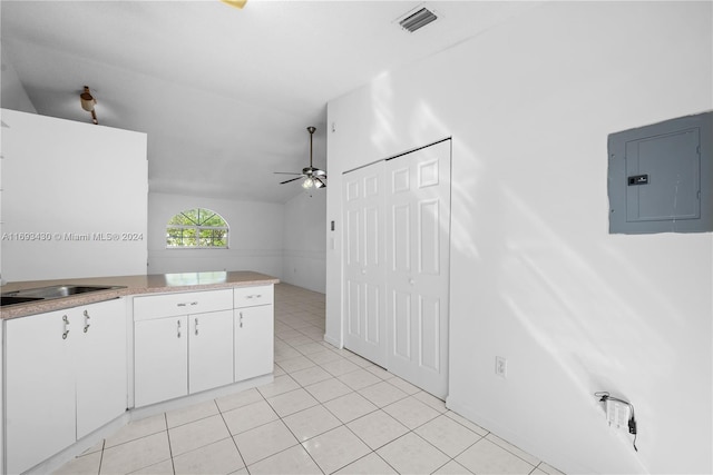 kitchen with ceiling fan, sink, light tile patterned flooring, electric panel, and white cabinets