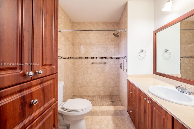 bathroom featuring tile patterned floors, vanity, toilet, and tiled shower