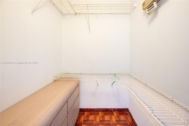 spacious closet with dark parquet flooring