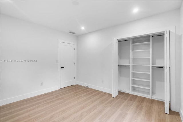 unfurnished bedroom with light hardwood / wood-style flooring and a closet