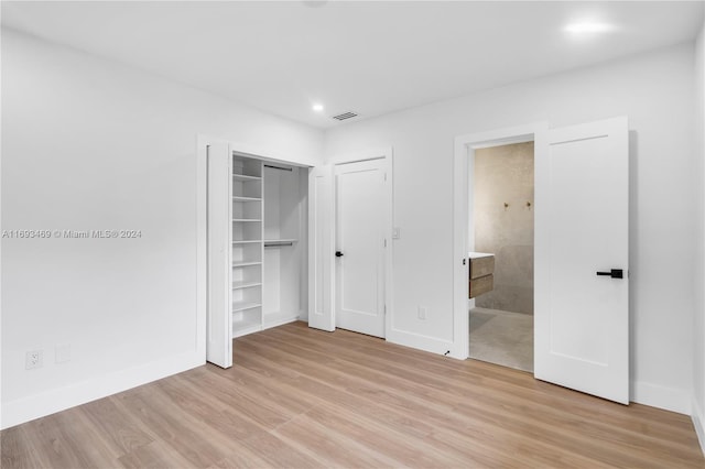 unfurnished bedroom with light wood-type flooring and ensuite bath