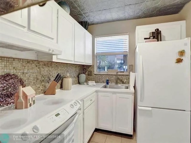 kitchen featuring sink, light tile patterned flooring, backsplash, white appliances, and white cabinets