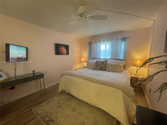 bedroom with hardwood / wood-style floors, a textured ceiling, and ceiling fan