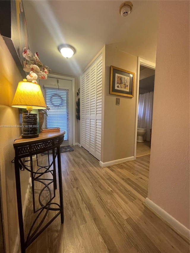 hallway with hardwood / wood-style flooring