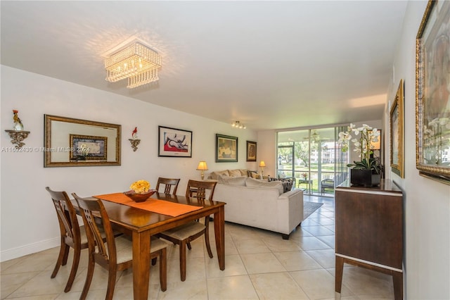 tiled dining room featuring an inviting chandelier