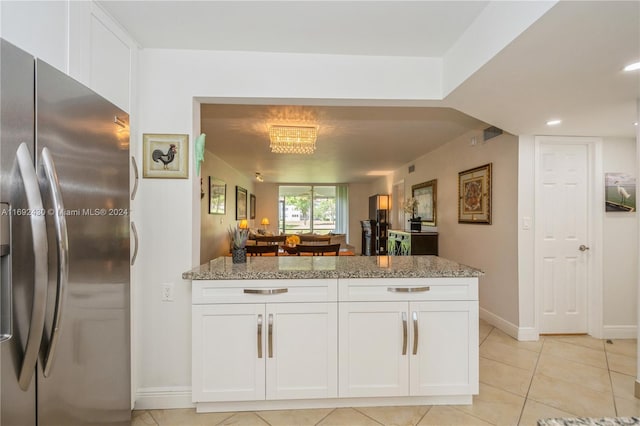 kitchen with stainless steel fridge with ice dispenser, white cabinets, light stone countertops, and light tile patterned floors