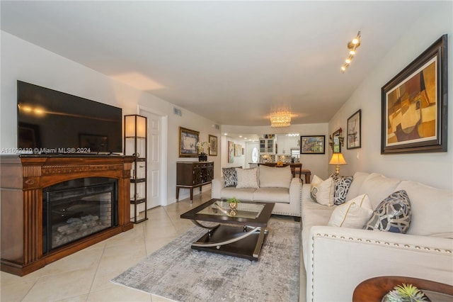 tiled living room with a notable chandelier